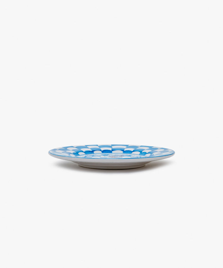 Palio Small Plate in white glazed ceramic with blue designs, side view.