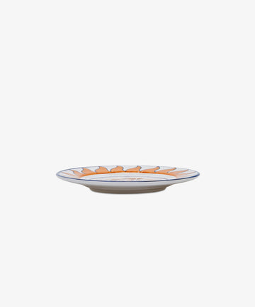 Palio Small Plate in white glazed ceramic with orange and blue designs, side view.