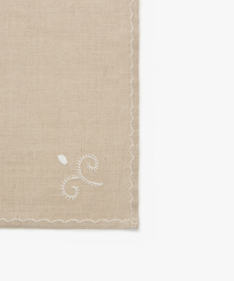Close-up of white stitching on tan cotton Inez Napkin.