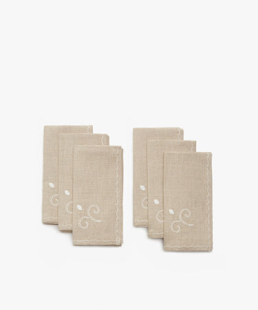 Inez Napkin. Two stacks of three napkins in tan cotton with white cotton stitched decorative details.
