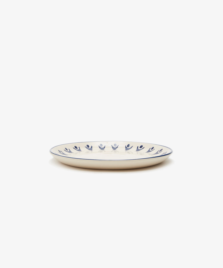 Vito Small Plate. White stoneware side plate with painted blue rim and design details, side view.