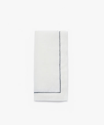 Single Lorna Hemstitch Napkin in white linen with dark blue stitching.